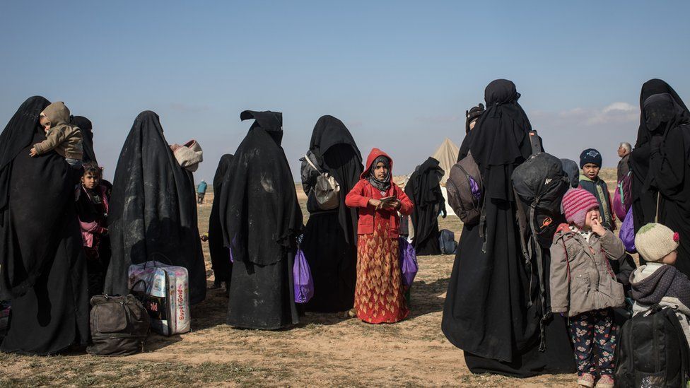 Civilians who have fled fighting in Baghuz wait to board trucks after being screened by members of the Syrian Democratic Forces (SDF) on February 9