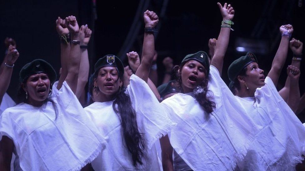 A choir of members of the Colombian Revolutionary Armed Forces of Colombia (FARC) guerrilla sing at the end of the broadcasting of the signing of the peace at El Diamante rebel camp, Caqueta department, Colombia on September 26, 2016