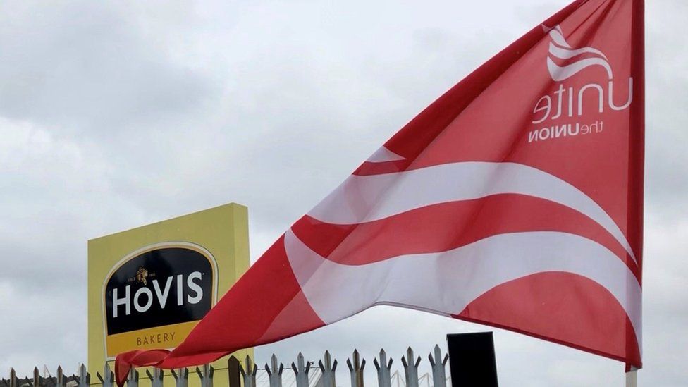 Unite flag waving in front of Hovis signage outside factory