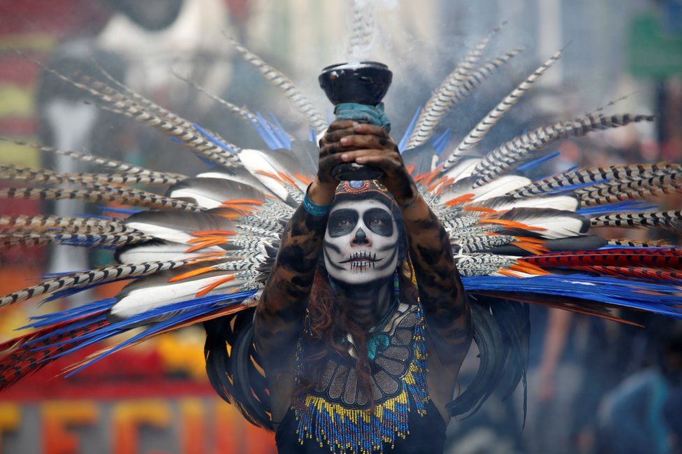 A participant holds up a censer during the annual Day of the Dead parade in Mexico City
