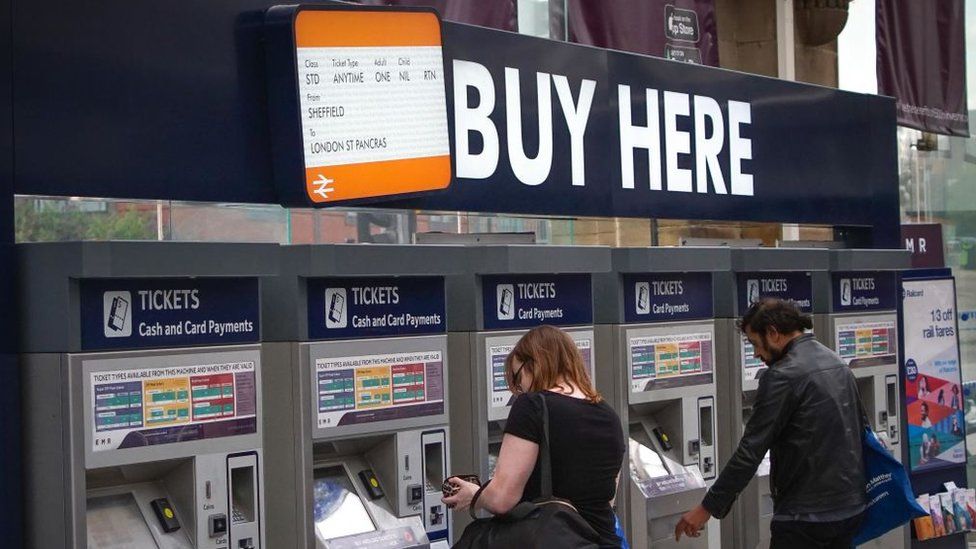 People buying train tickets from ticket machines at Sheffield train station