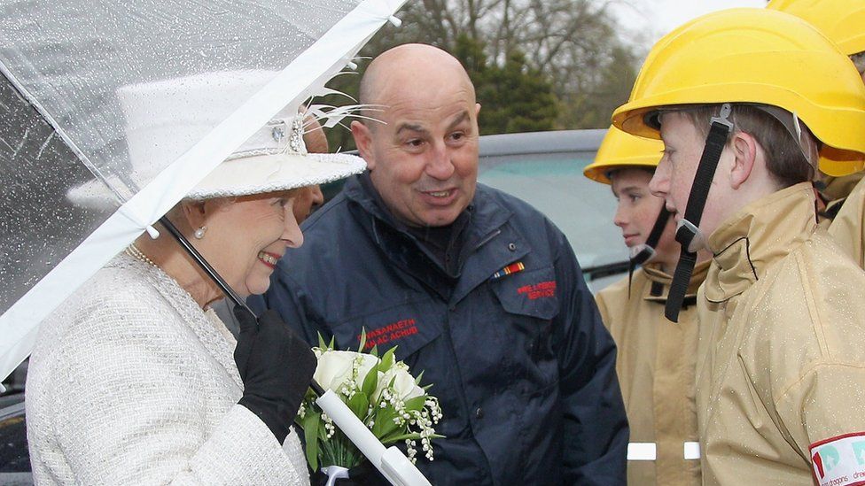 Queen Elizabeth II holds an umbrella during a rain shower as she visits Cyfarthfa High School and Castle on April 26, 2012 in Merthyr, Wales