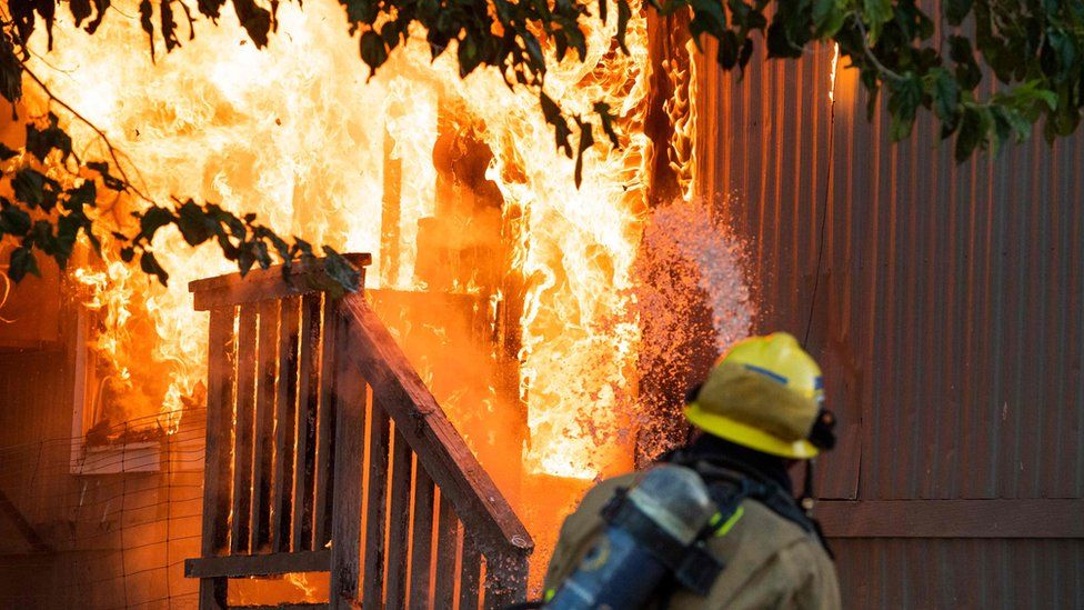 Firefighters battle an electrical fire in a mobile home park in Ridgecrest, California,