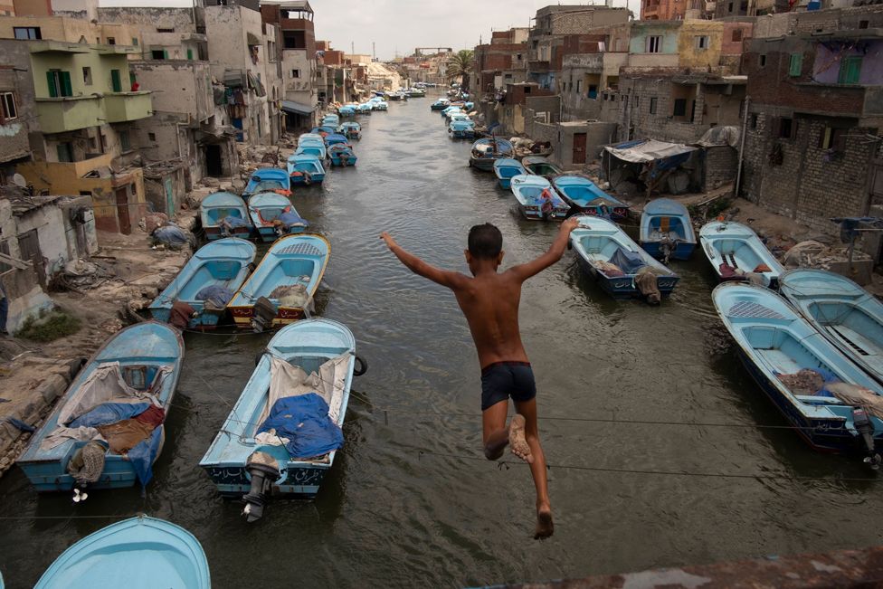 A young boy jumps into water, Alexandria, Egypt - 16 Mar 2021