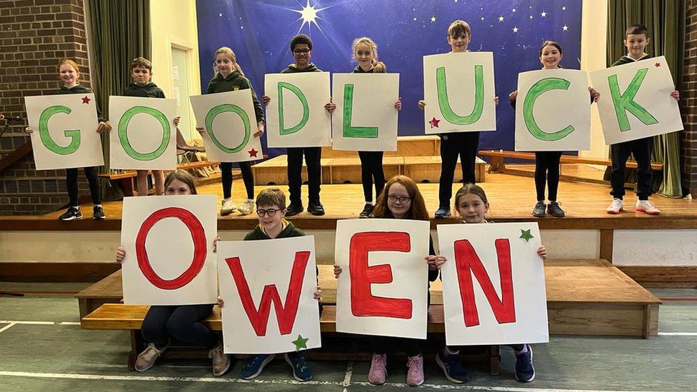 Pupils with 'Good Luck Owen' signs