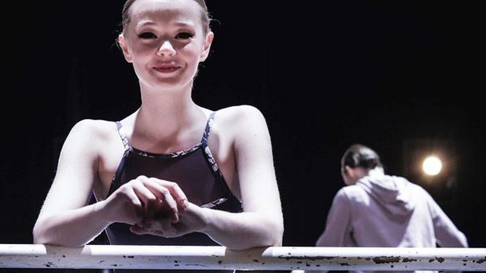 A member of Kyiv City Ballet leaning on ballet bar
