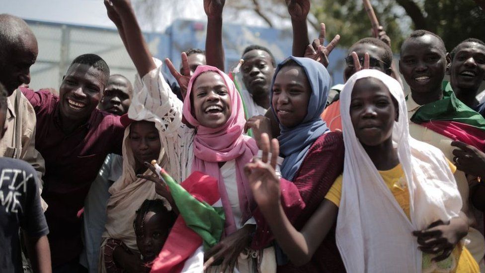 Sudanese men and women celebrate outside the Friendship Hall in the capital Khartoum where generals and protest leaders signed a historic transitional constitution meant to pave the way for civilian rule in Sudan, on August 17, 2019