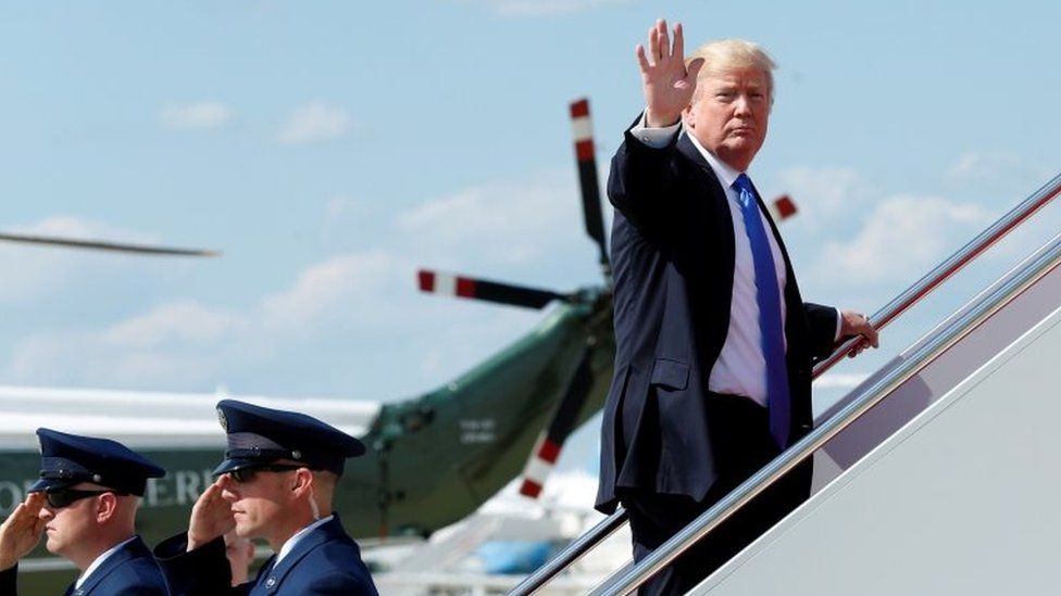 US President Donald Trump waves as he boards Air Force One at Joint Base Andrews near Washington, DC before travelling to Bedminister, New Jersey, for the weekend.