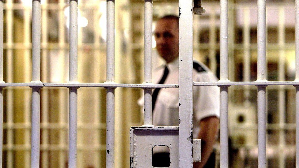Prison officer seen through bars