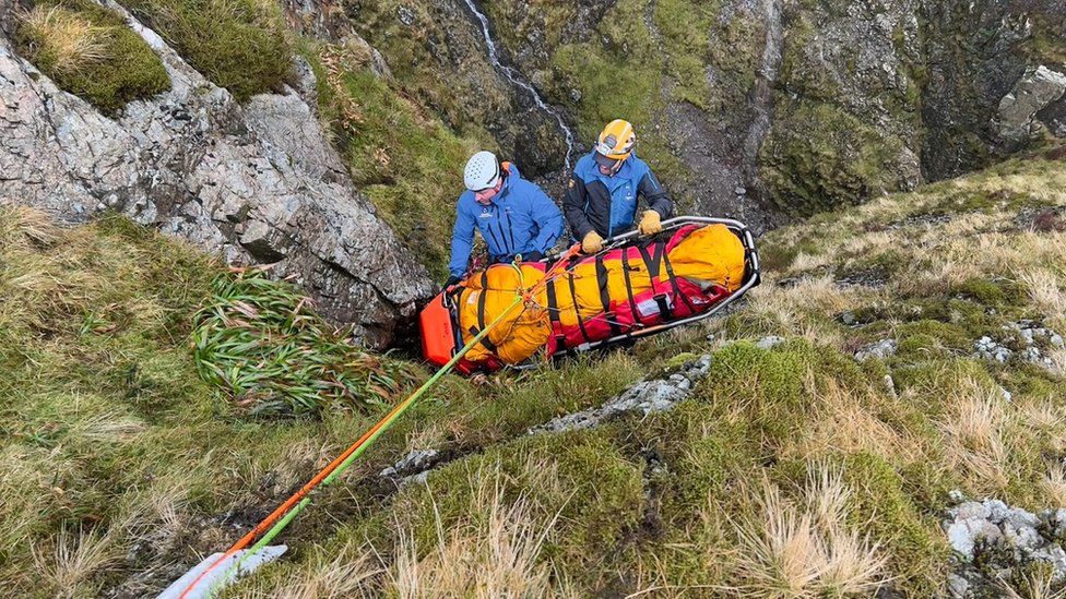 Mountain rescue volunteers hauling the casualty out of the gill with a stretcher on a rope
