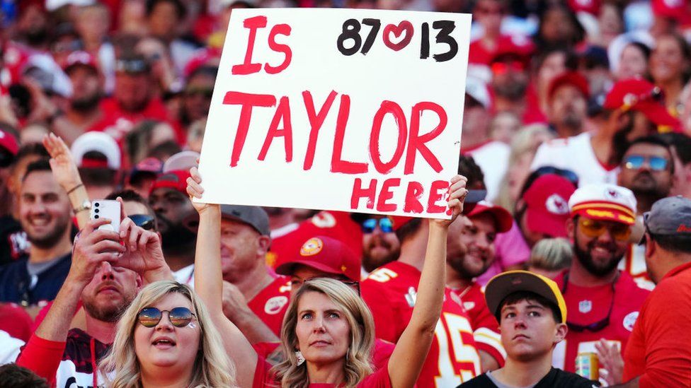 A Chiefs fan holds up a sign about Taylor Swift