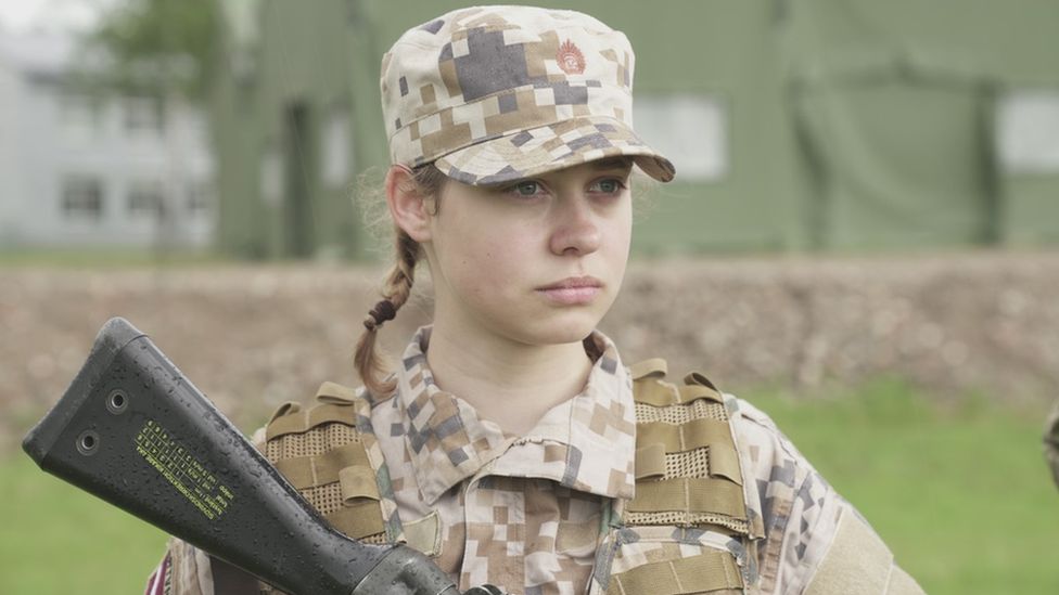 Uma mulher segurando um rifle