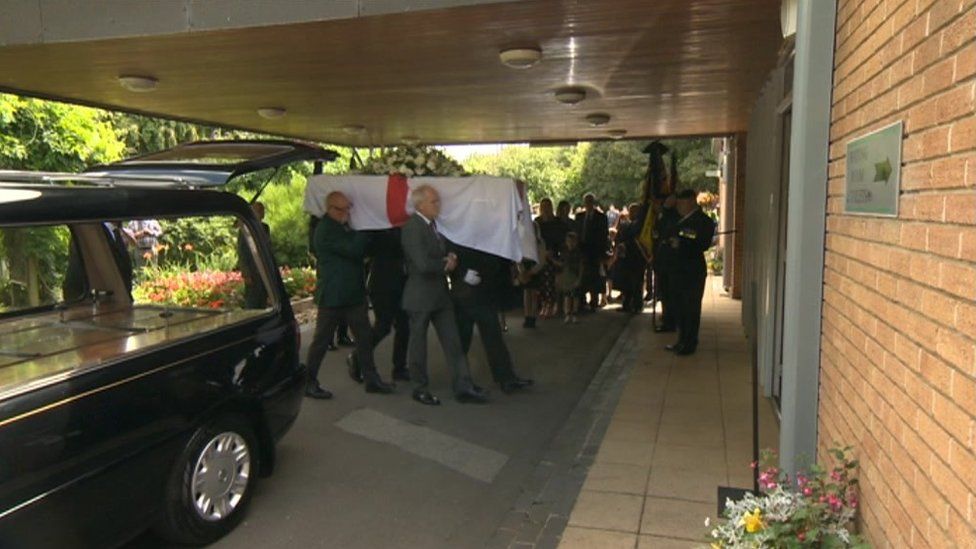 Mr Walsh's coffin being carried into the crematorium