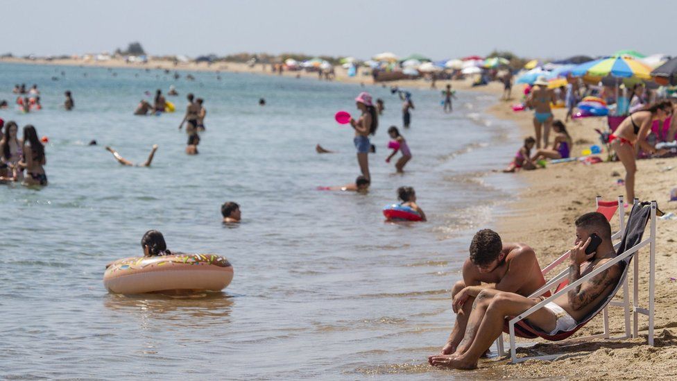 Holidaymakers on beach in Greece