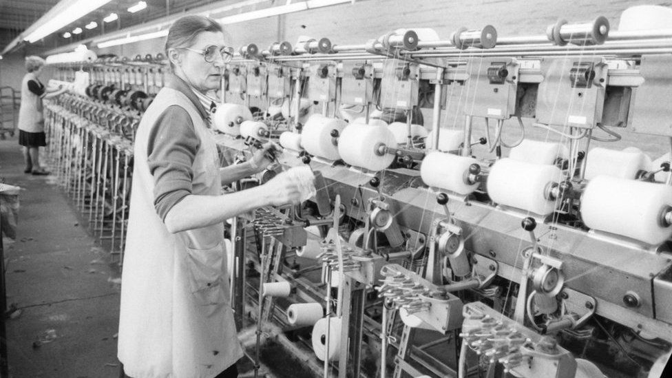 Woman working at a thread spinning machine