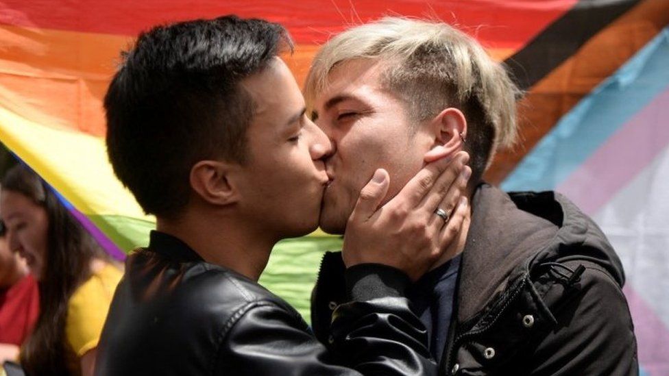 Сантьяго Мальдонадо и Хорхе Эстебан Фариас целуются как часть протест после нападения людей во время поцелуя в общественном парке в Боготе, Колумбия, 31 июля 2022 г.