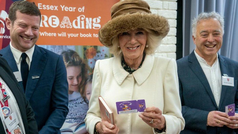 The Queen Consort with Dermot O'Leary and Frank Cottrell-Boyce and is holding her Essex library card