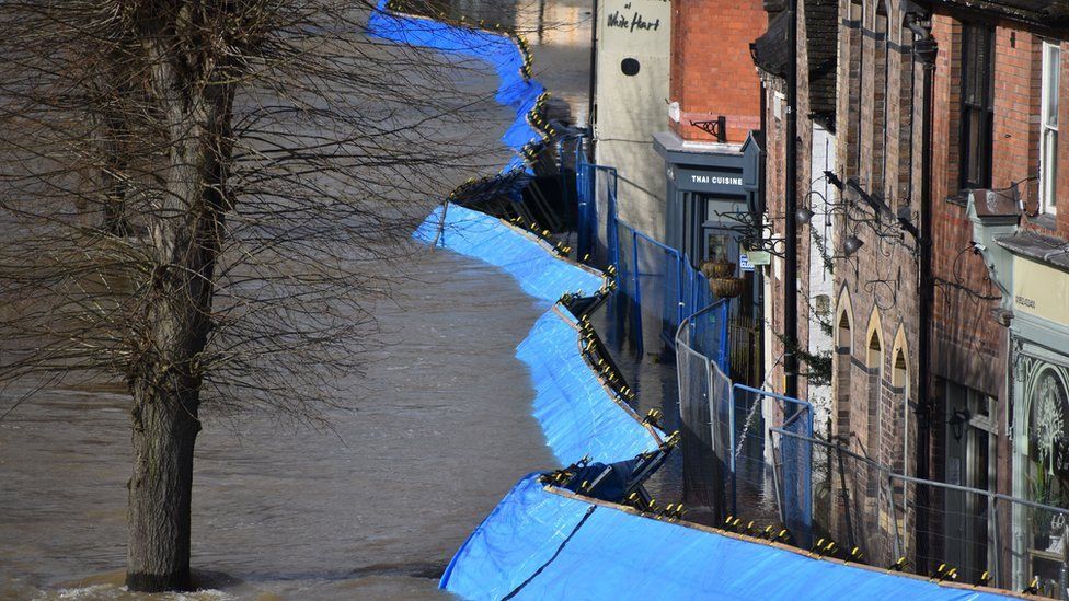 Temporary flood barriers which have been moved by the River Severn towards the Wharfage in Ironbridge