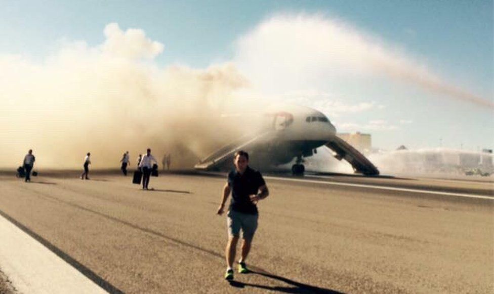 A passenger runs as the smoke billows from the plane 9 September 2015