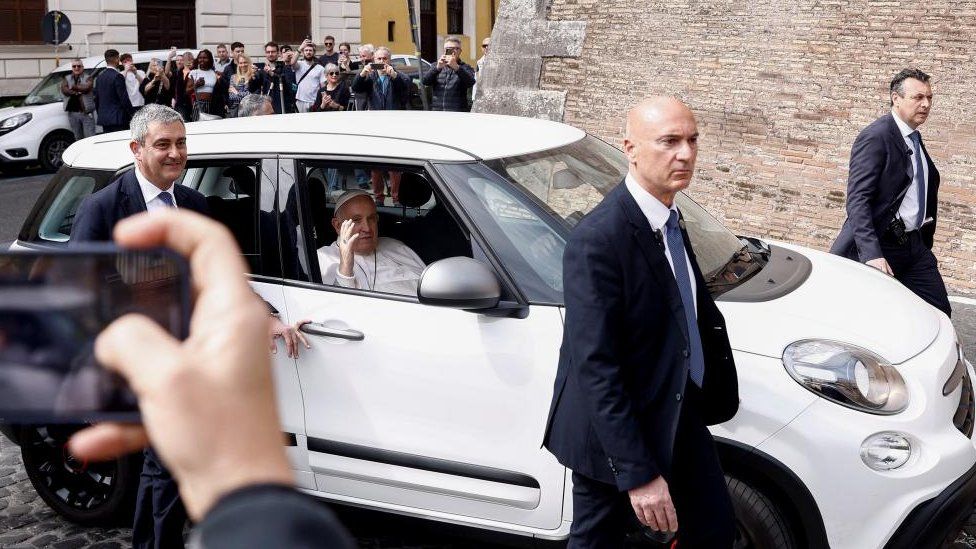 Pope Francis waves as he rides in a car near the Vatican after having been discharged from Gemelli hospital in Rome, Italy, April 1, 2023