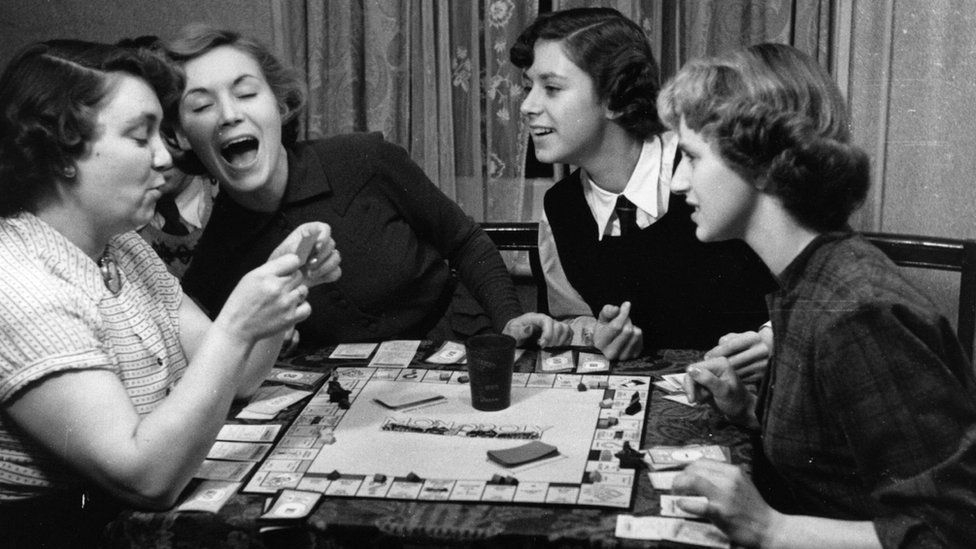 A teacher and some girls playing monopoly in 1951
