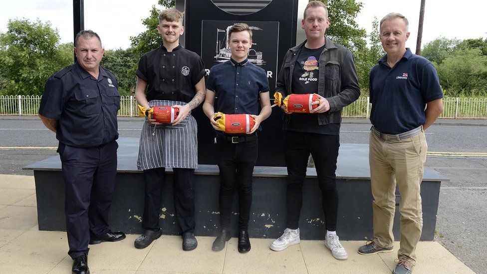 Firefighter Tommy Richardson of TWFRS, patron Matthew Cadas, Chef Tyler Wemyss, General Manager Mark Halliday, and Tony Wafer, Senior Water Safety Manager, RNLI, stand in a row outside the pub