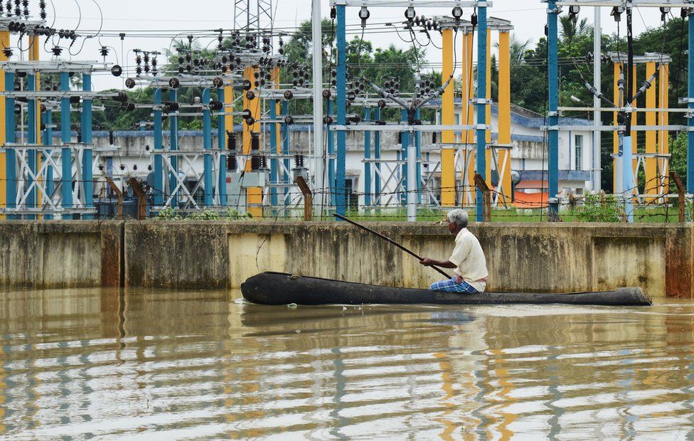 A man rowing past an electricity grid