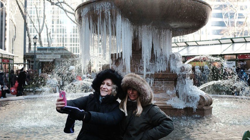 New York tourists take selfie in front of frozen fountain