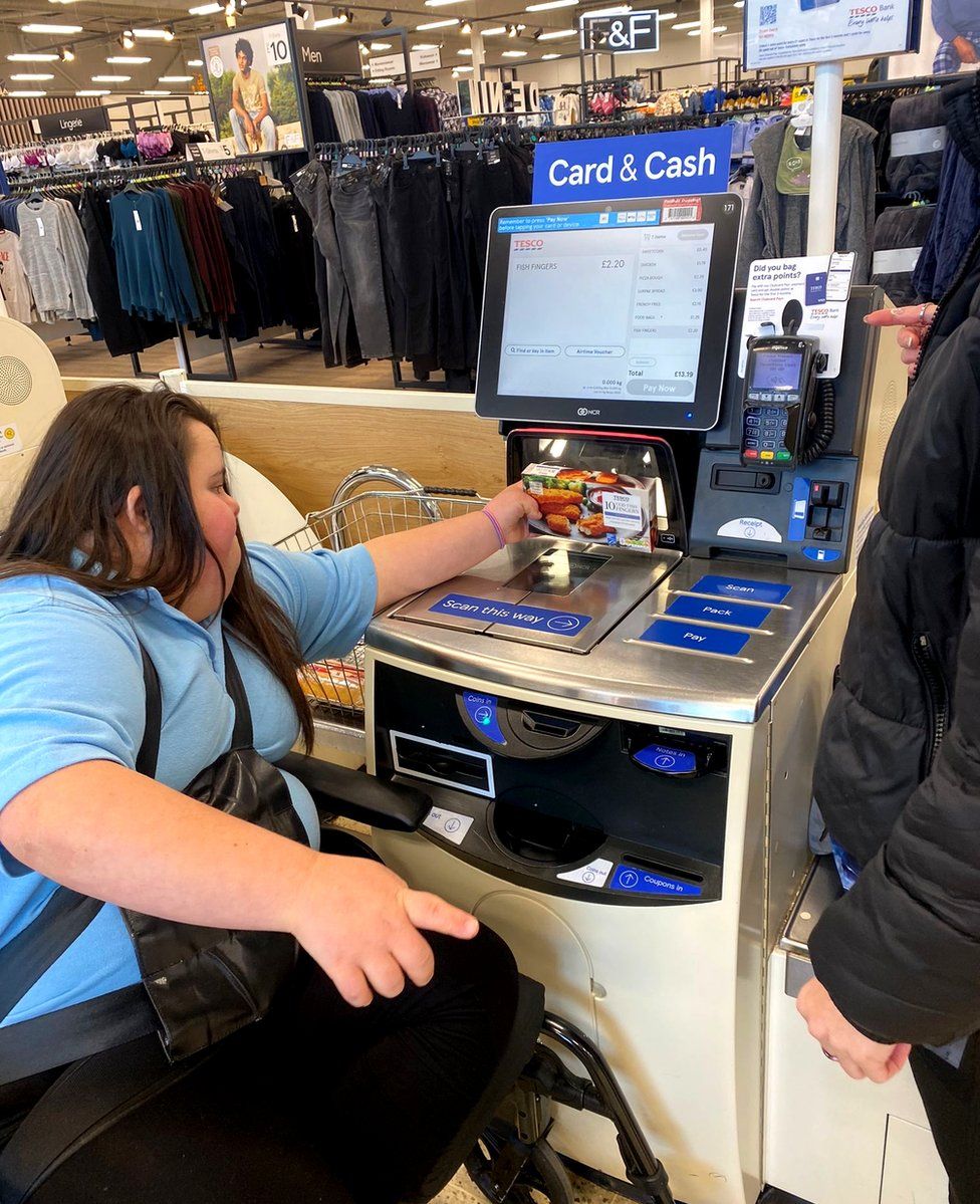 Chloe putting her shopping through a self checkout