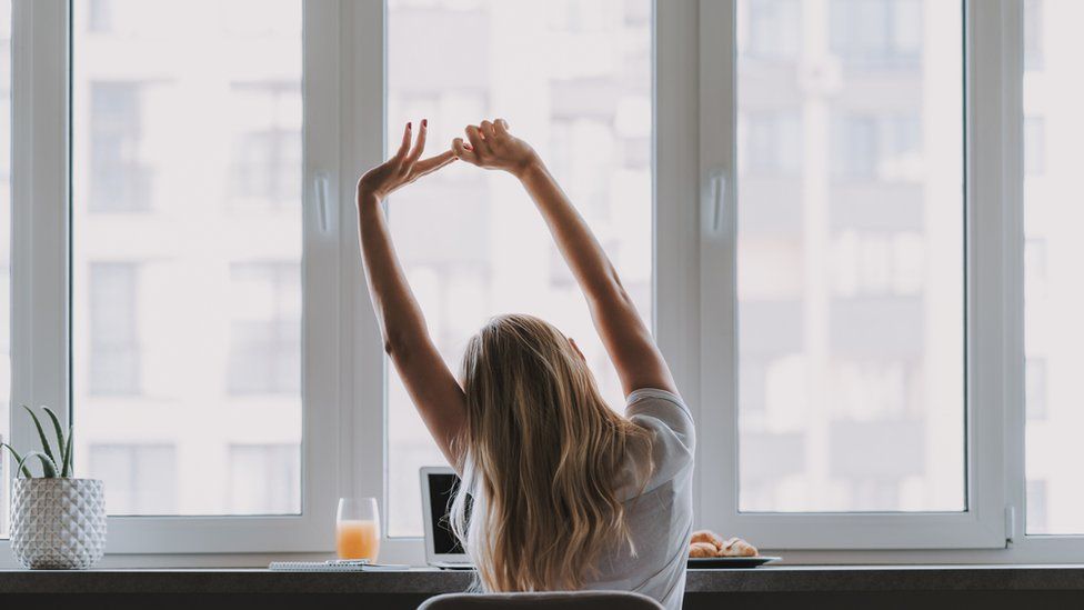 A woman stretches during a break