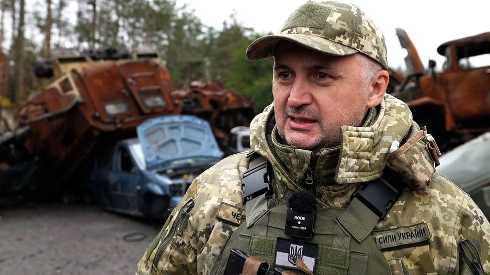 A Ukrainian army spokesman Col Cherevatyi speaks to the BBC, with destroyed Russian vehicles in the background