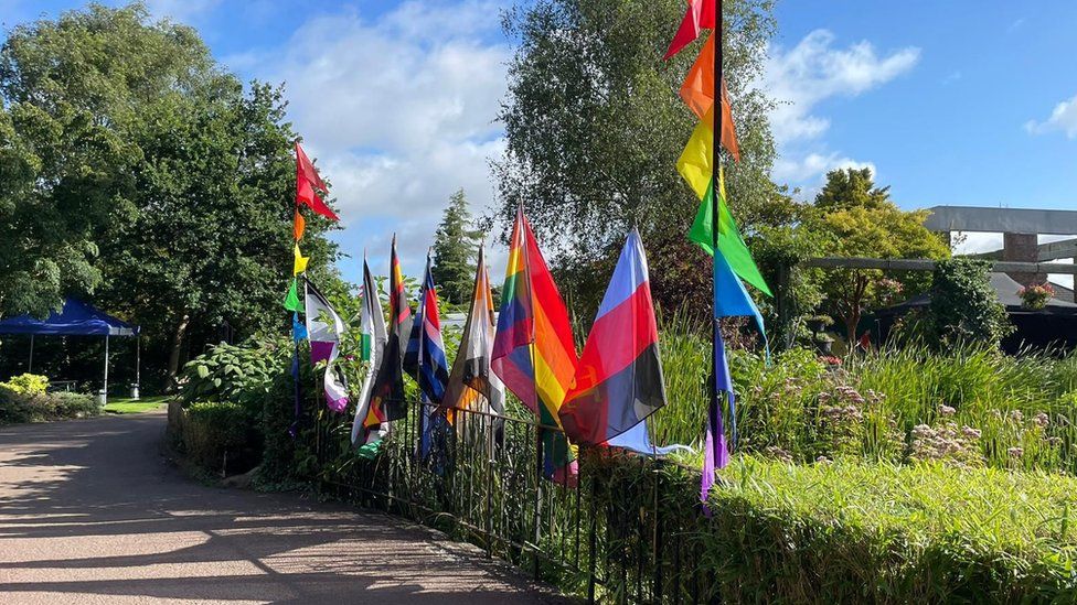 Pride flags by a gate