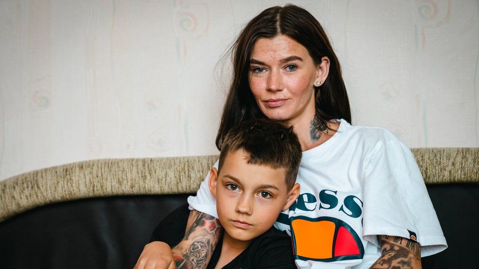 Inga sits on a sofa with her son