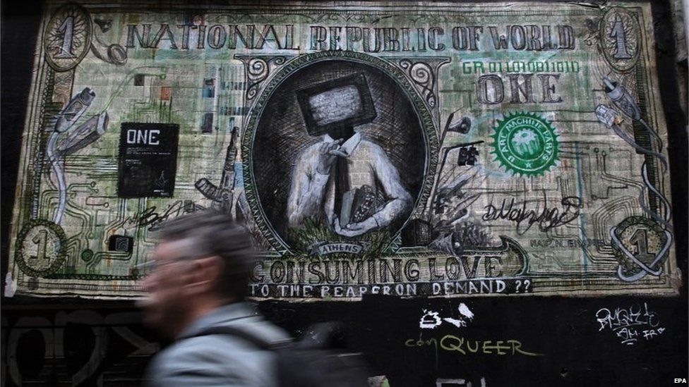 A man walks past a graffiti depicting a banknote in Athens,