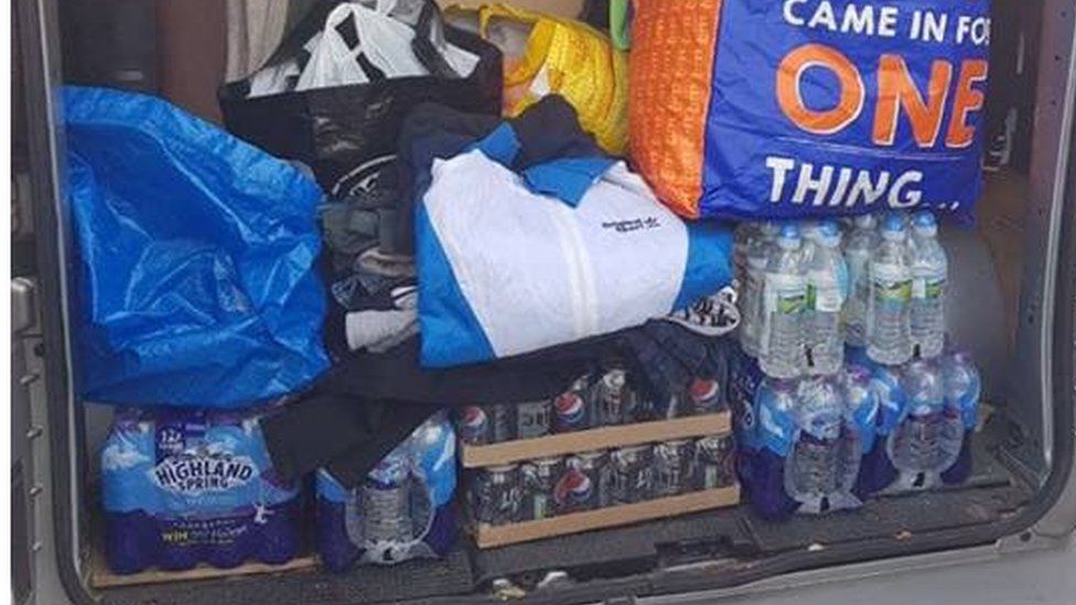 The back of a van loaded with bottled water and other items