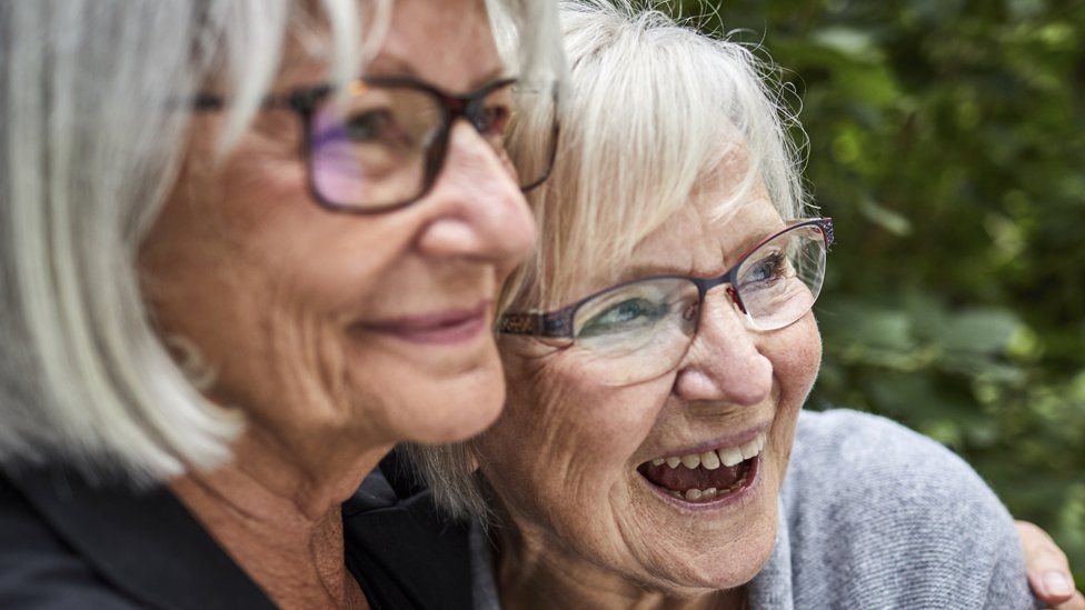 Older women laughing and hugging