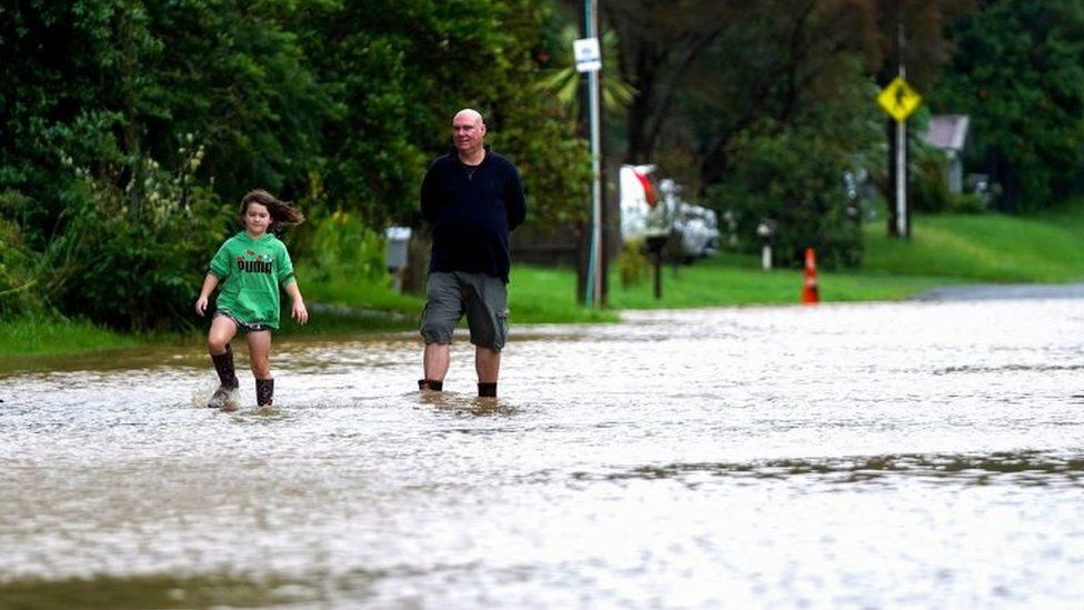 Два человека идут по затопленной дороге в Новой Зеландии