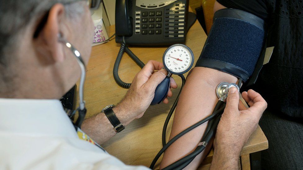 A doctor checks a patient's blood pressure