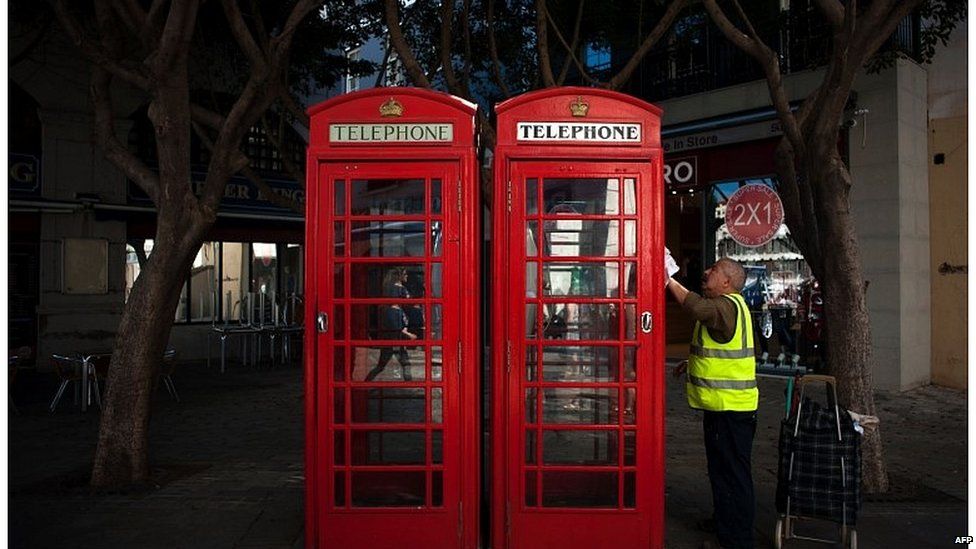 Man cleaning telephone boxes in Gibraltar