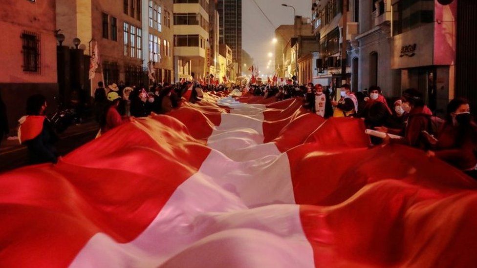 Сторонники кандидата в президенты Перу Педро Кастильо несут большой перуанский флаг на улице через день после второго тура выборов в Лиме, ​​Перу, 7 июня 2021 г.