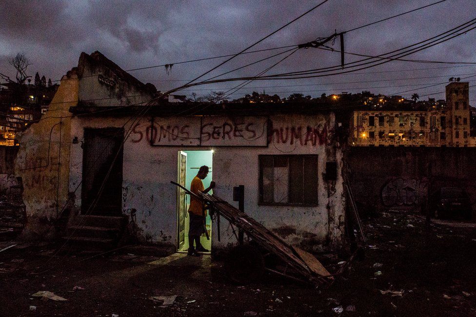 Man standing at the doorway of an occupied house