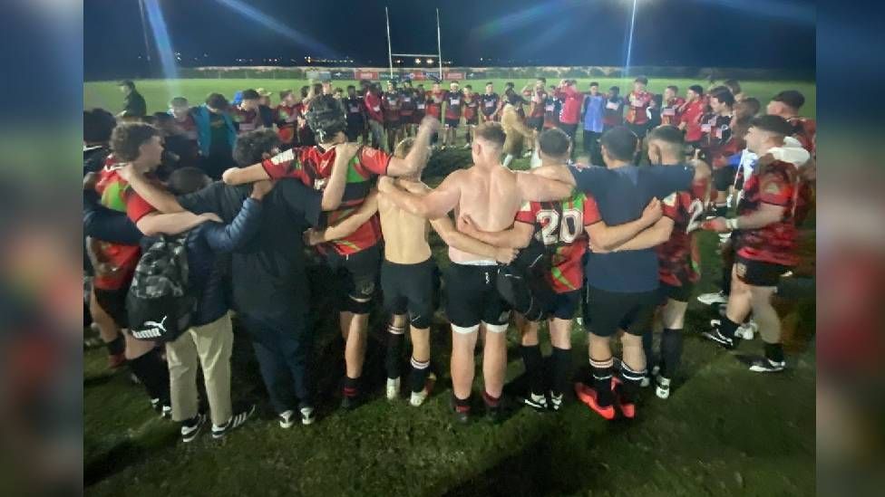 Boys hugging after playing rugby