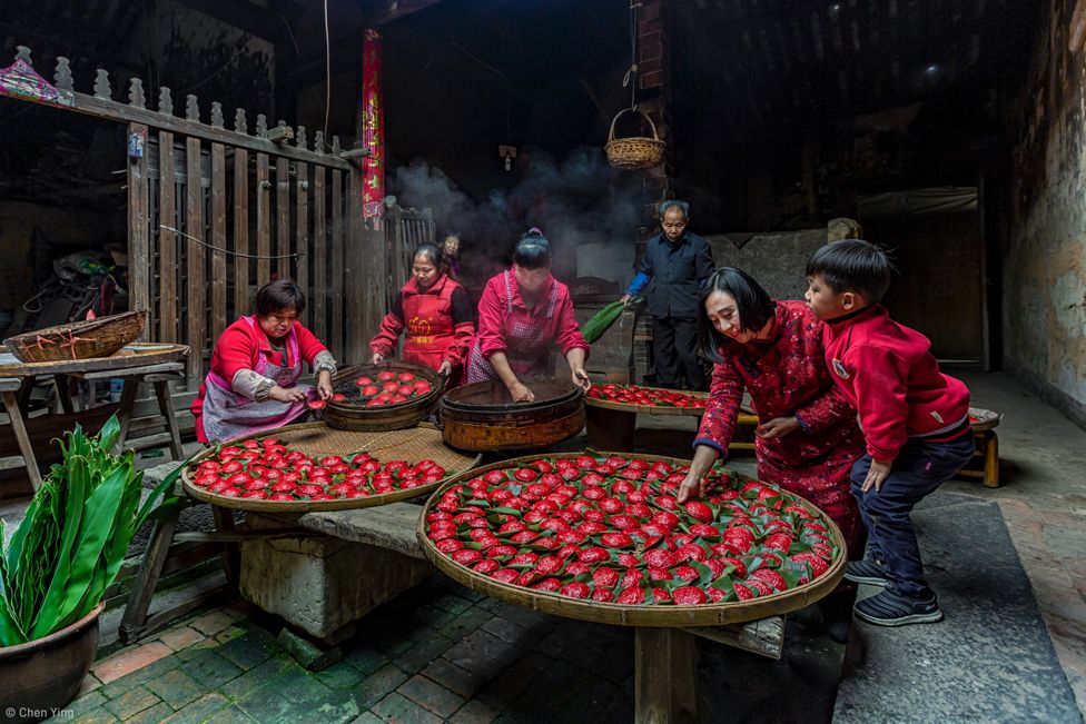 A family making red colored dumplings: