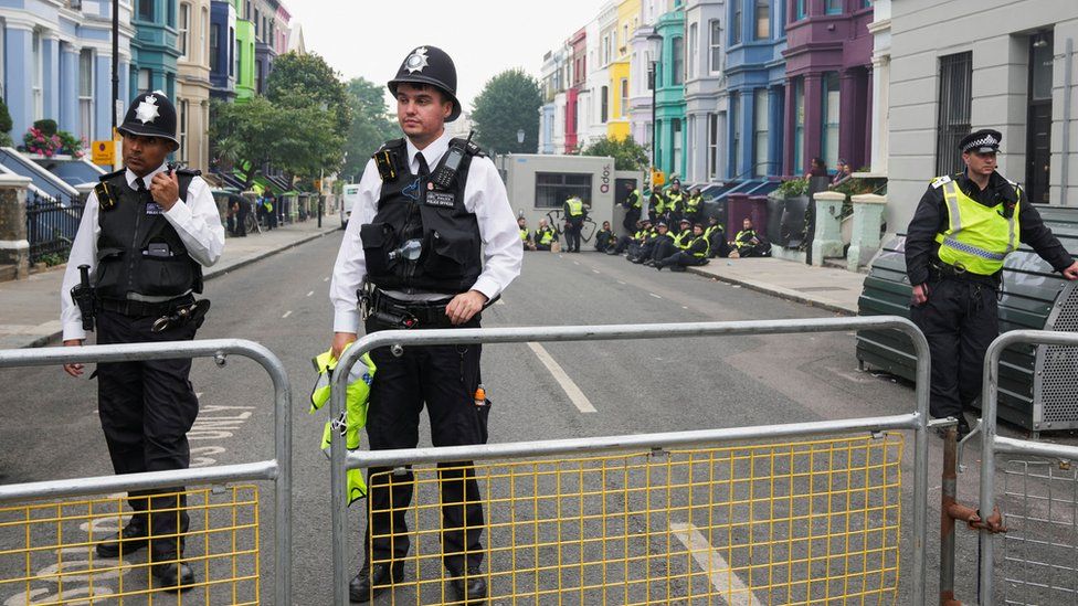 Police officers stand guard during the Notting Hill Carnival, in London, Britain