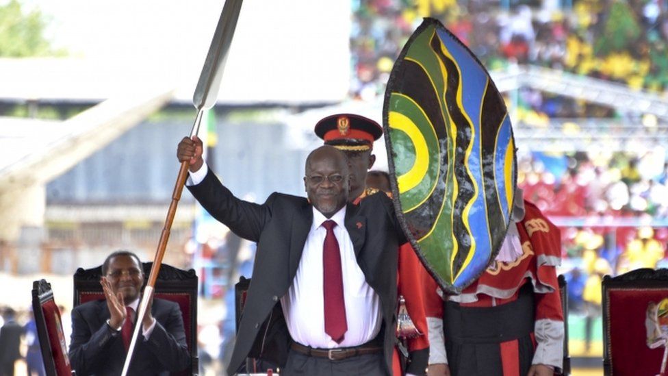 Tanzania's new President John Pombe Magufuli holds up a ceremonial spear and shield to signify the beginning of his presidency, shortly after swearing an oath during his inauguration ceremony at Uhuru Stadium in Dar es Salaam, Tanzania Thursday, Nov. 5, 2015
