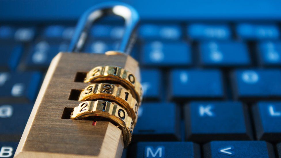 This stock image shows a padlock lying on top of a laptop's keyboard