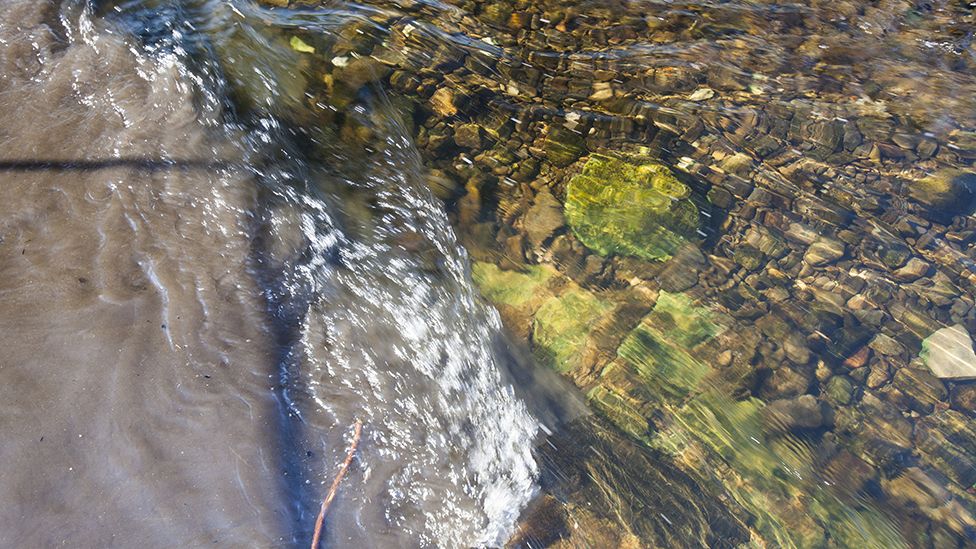 Raw sewage mixing with clean clear water in the river Kent in Kendal, Cumbria, UK.