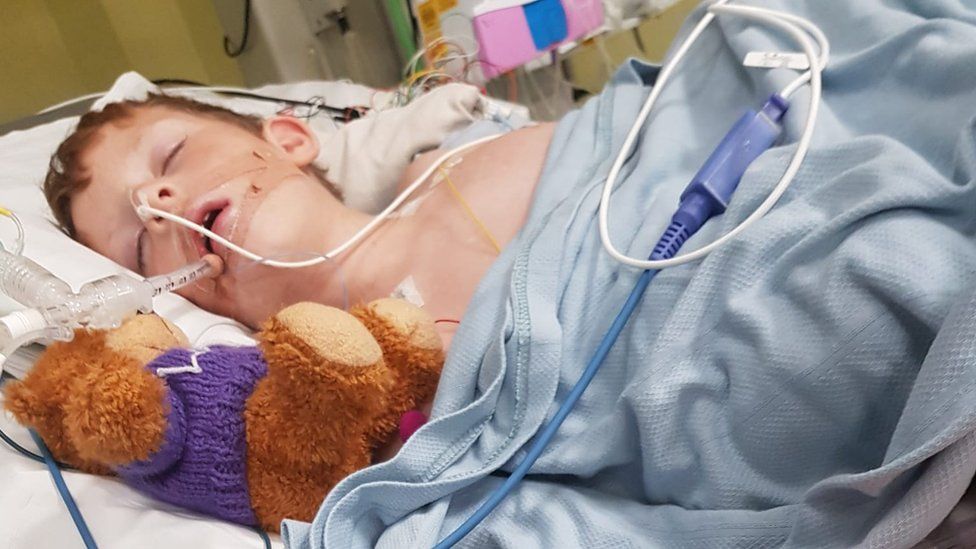 Toby in in hospital bed on the Paediatric Intensive Care Unit (PICU) at Bristol Royal Hospital for Children.