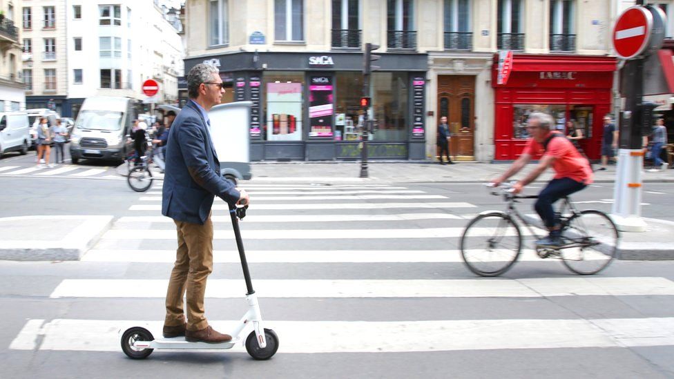 A man rides an electric scooter on the Rue de Rivoli street in Paris, France, 17 June 2019