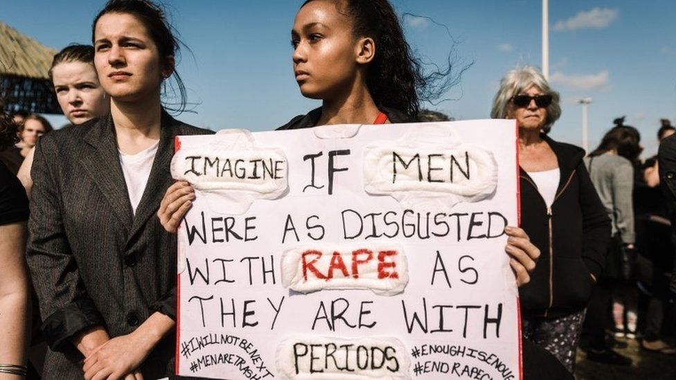 Protesters hold signs as they take part in a march against gender based violence and in solidarity with women who have been subject to violence and in memory of those who have been killed, at the North Beach in Durban, on September 7, 2019